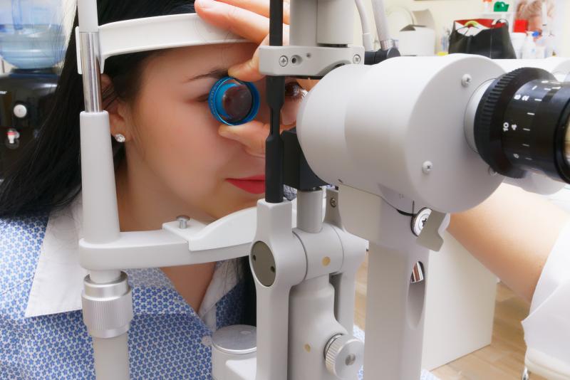La photo représente une dame en examen ophtalmologique