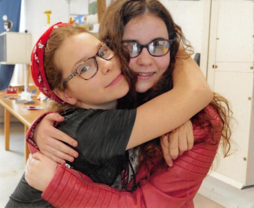 Romane, jeune adolescente ayant un handicap visuel et maîtresse de chien guide d'aveugle, pose avec Elona, sa meilleure amie